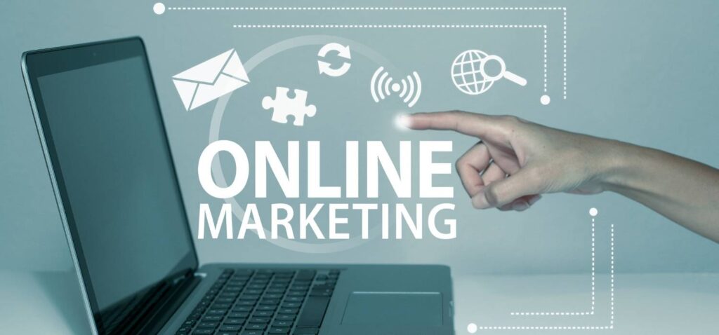 laptop dengan sudut samping dan kalimat "pemasaran online" di depan layar dengan ikon pemasaran digital mengelilinginya dan satu jari manusia menyentuhnya