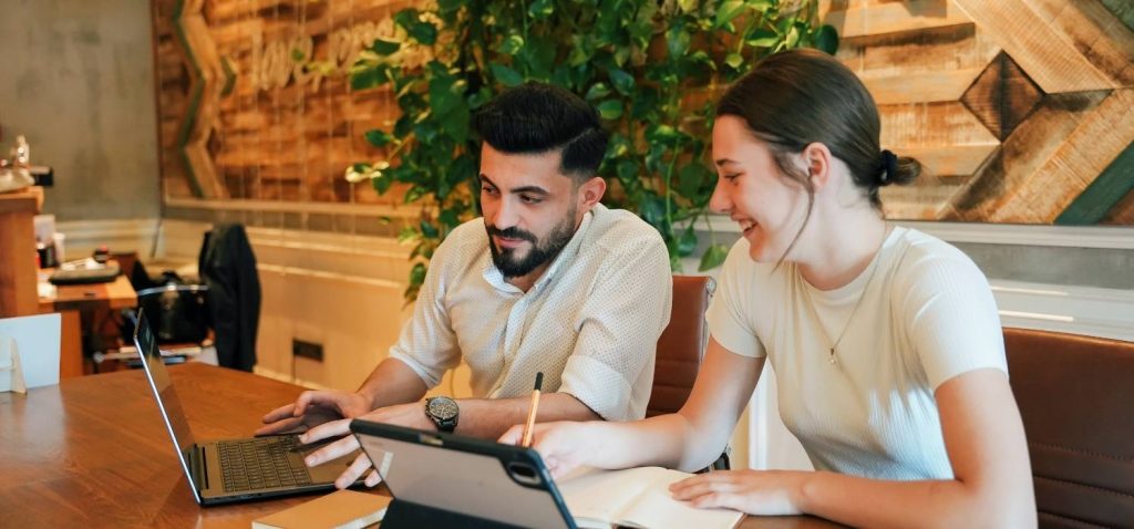 two people man and woman discuss about eco-friendly campaign with laptop in front of them