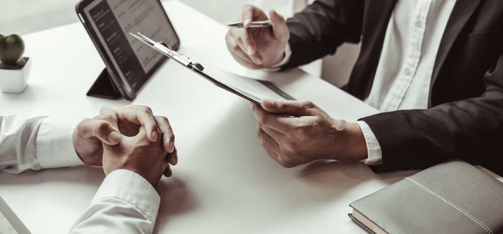 Seorang job hunter dengan kemeja putih dan recruiter dengan jas hitam sedang melakukan job hunting interview