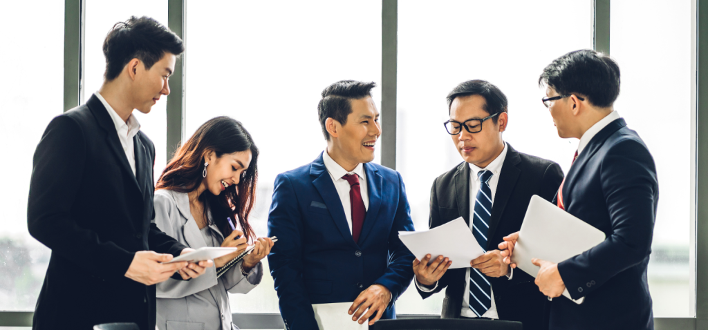 five professional looking employees having a discussion in the meeting room.